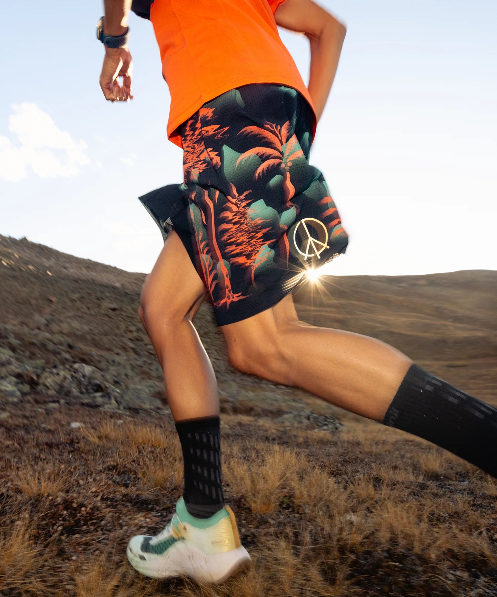 Person running on a mountain trail wearing salomon trail shoes photo by salomon
