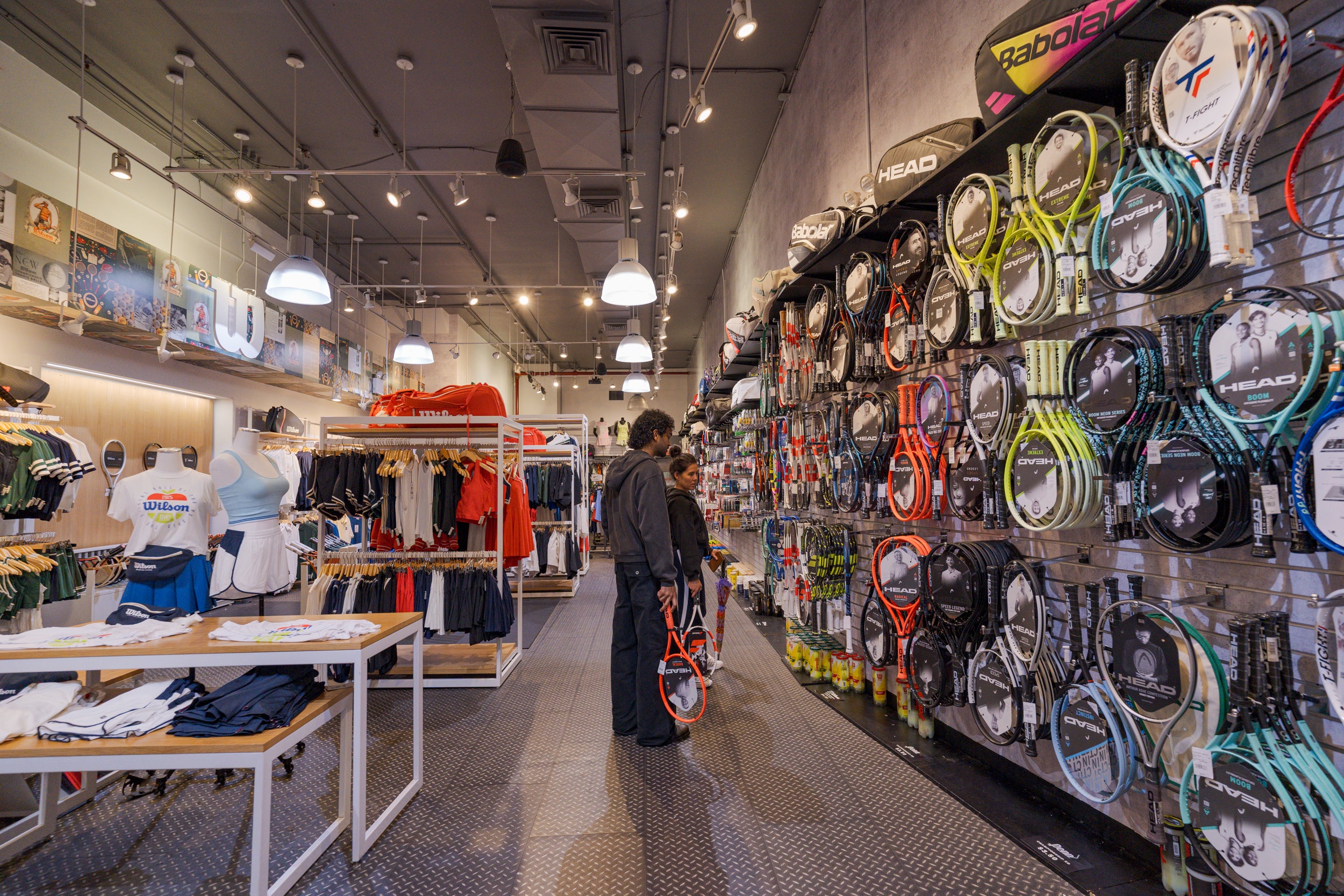 People shopping in a sports store with tennis rackets on display at Paragon Sports photo by Jose Crespof