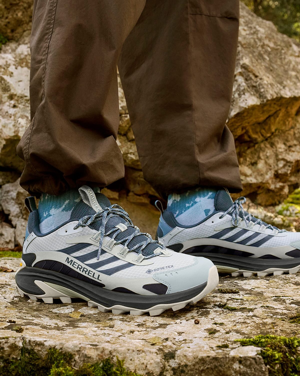 Person wearing Merrell hiking shoes on a rocky surface Photo by Merrell