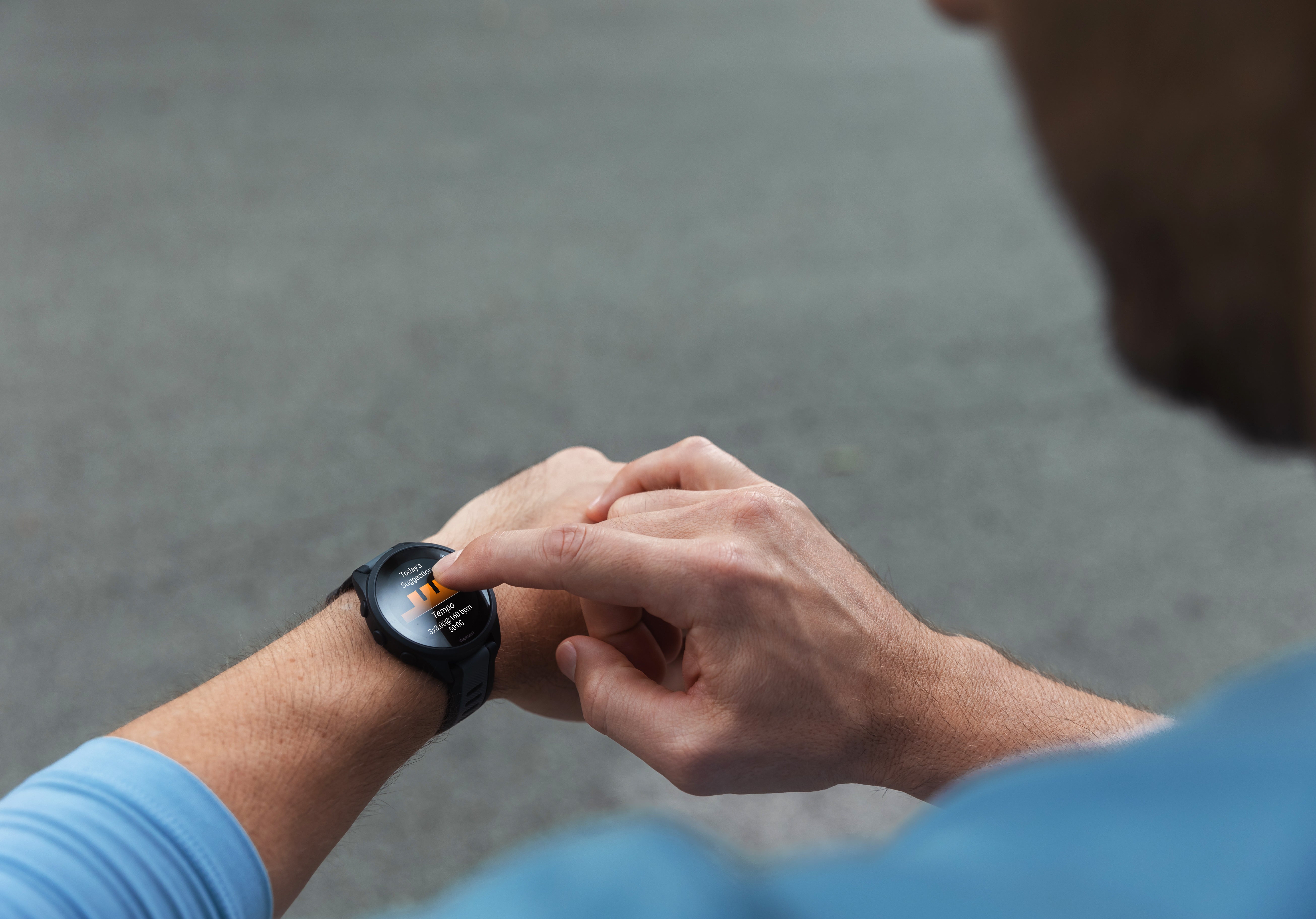Person interacting with a Garmin smartwatch on a blurred background Photo by Garmin