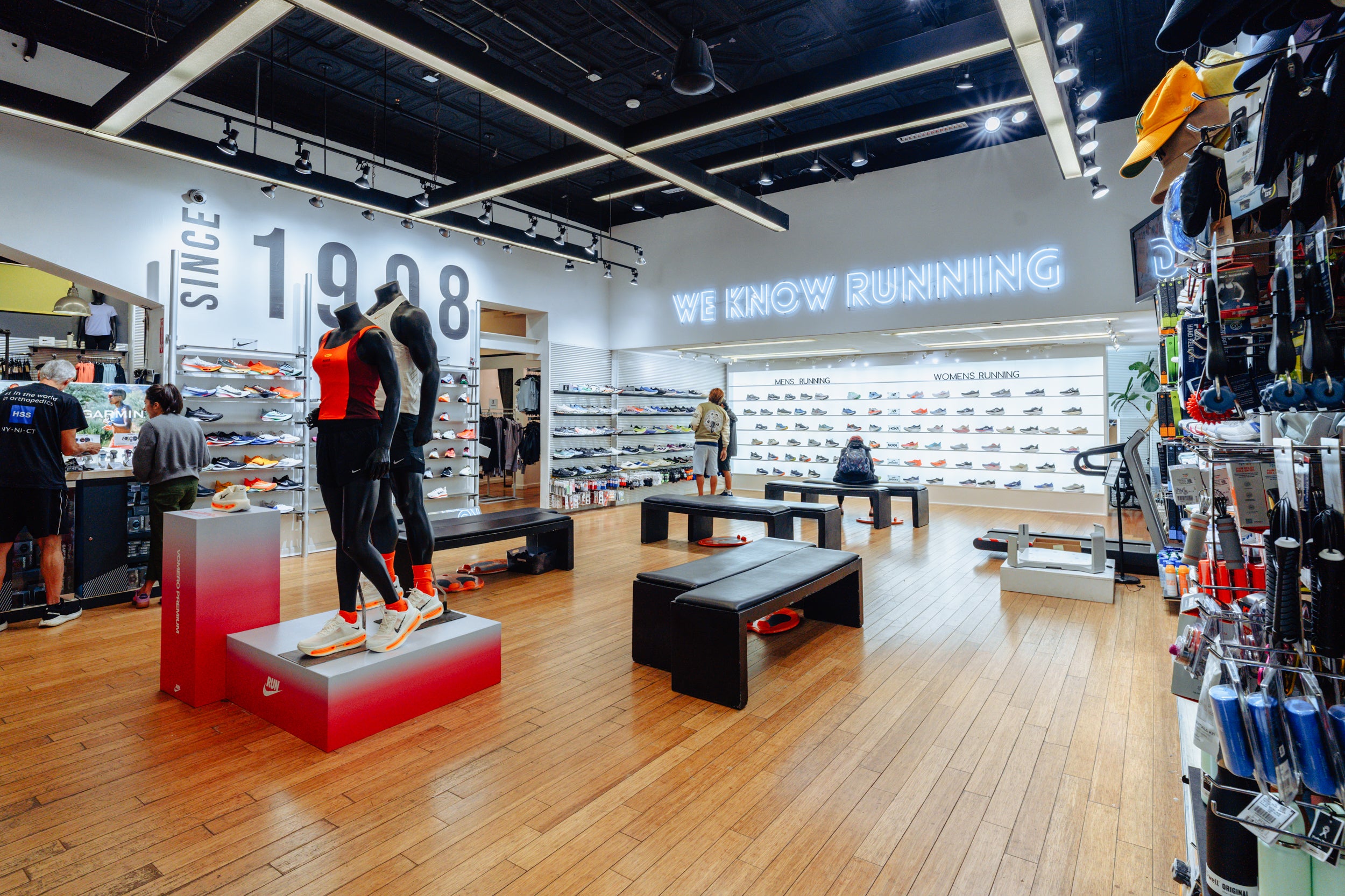 Interior of a running shoe store with mannequins and product displays.