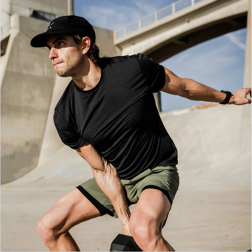 Man exercising outdoors on a concrete surface with a bridge in the background photo by Ten Thousand Brand
